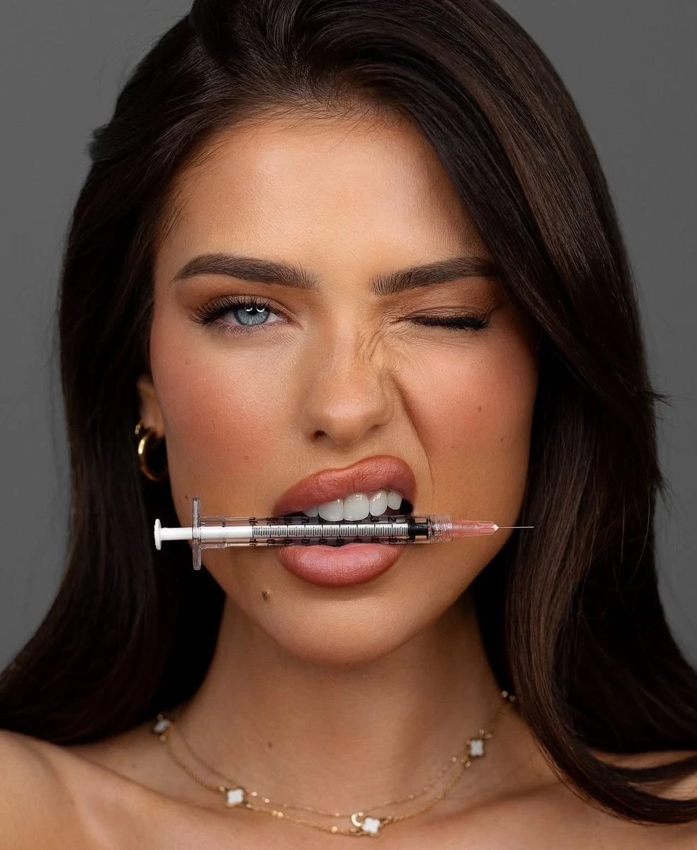 Women holding injection in mouth